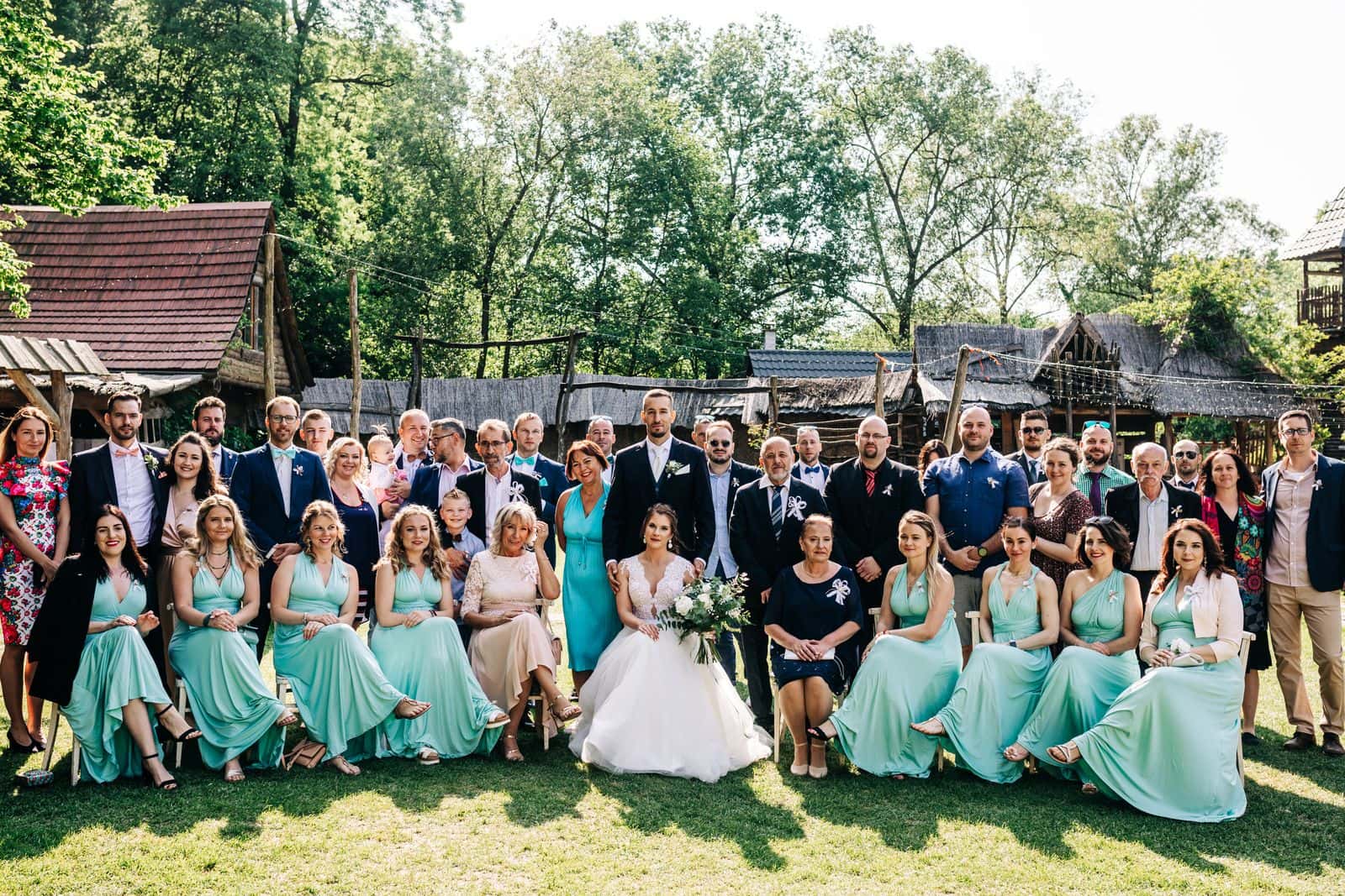 Newlyweds posing with a large group of wedding guests