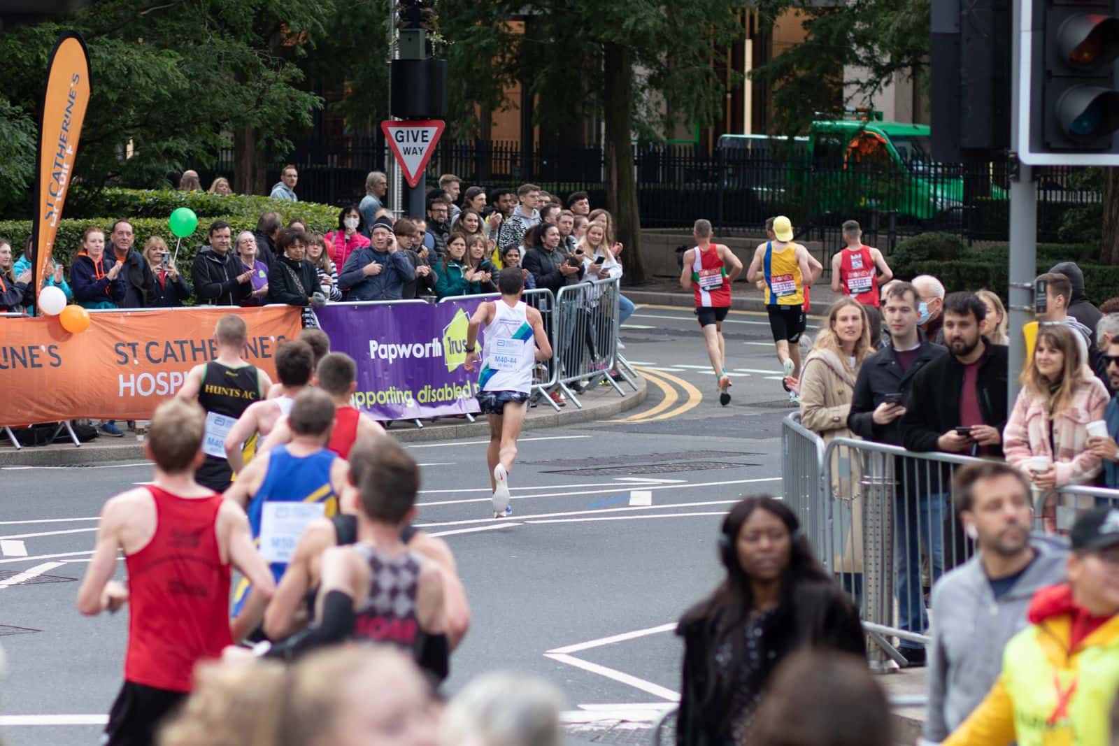Runners and spectators moving through a city marathon route