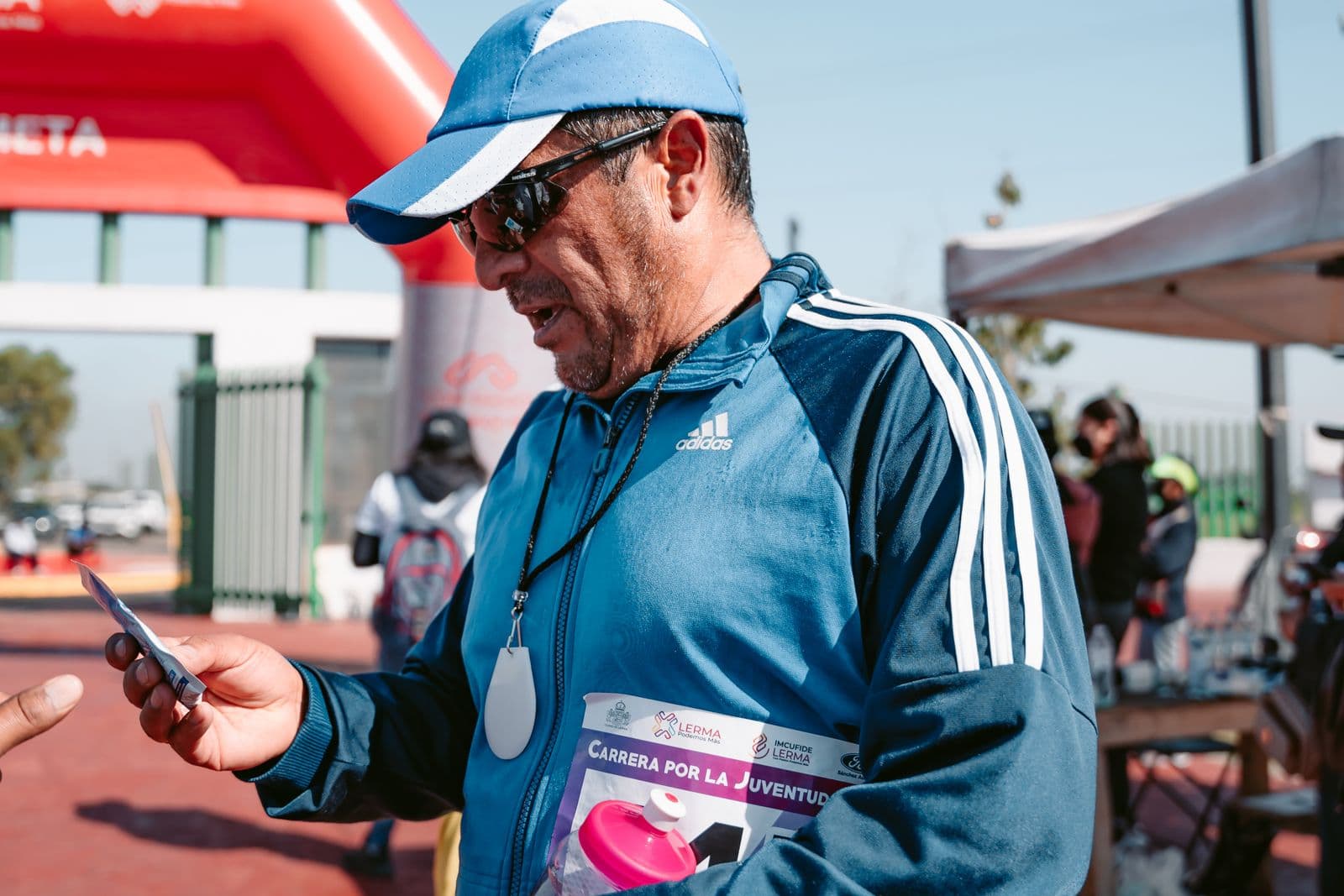 Race participant checking his phone after finishing