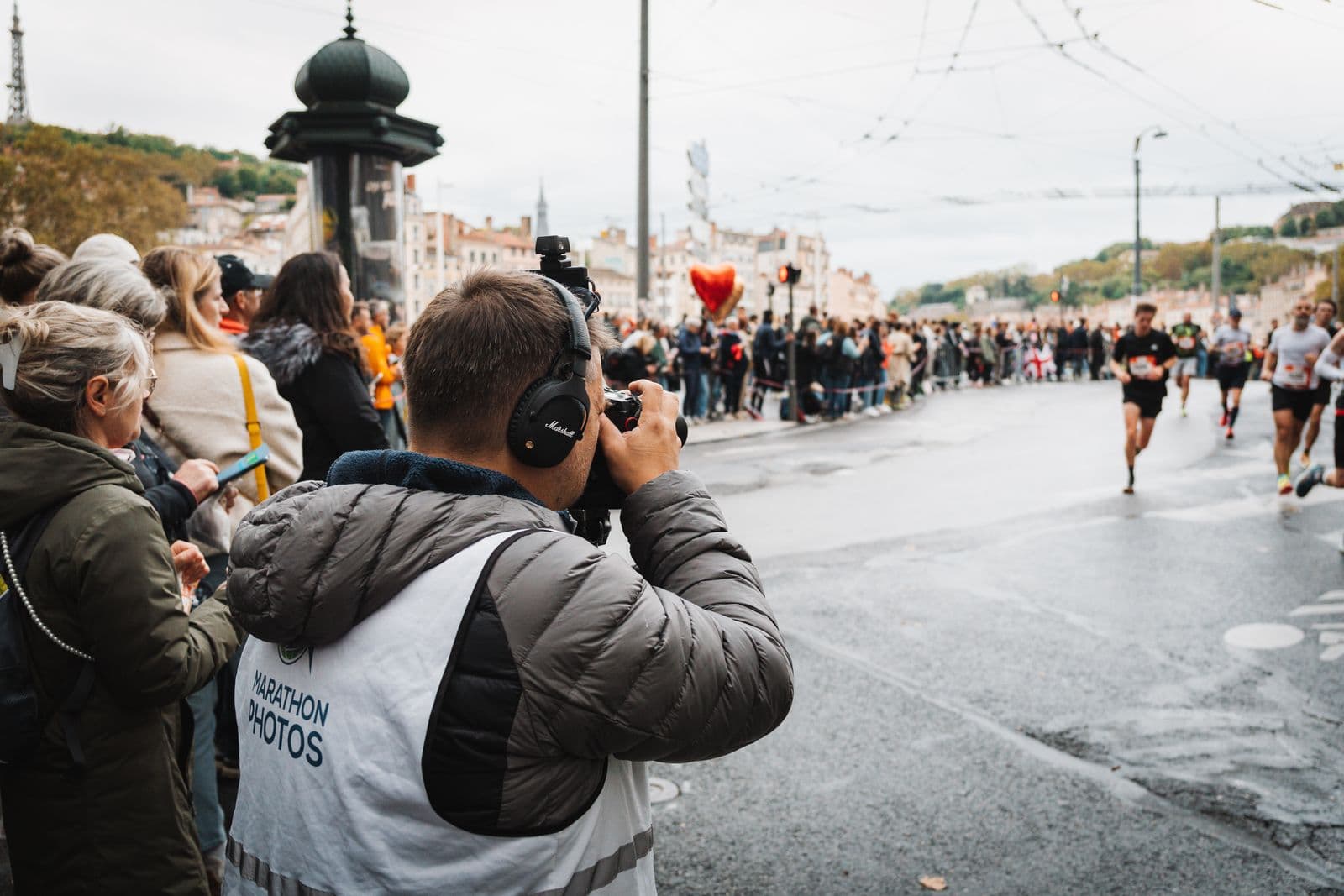 Race photographer capturing runners from the course edge