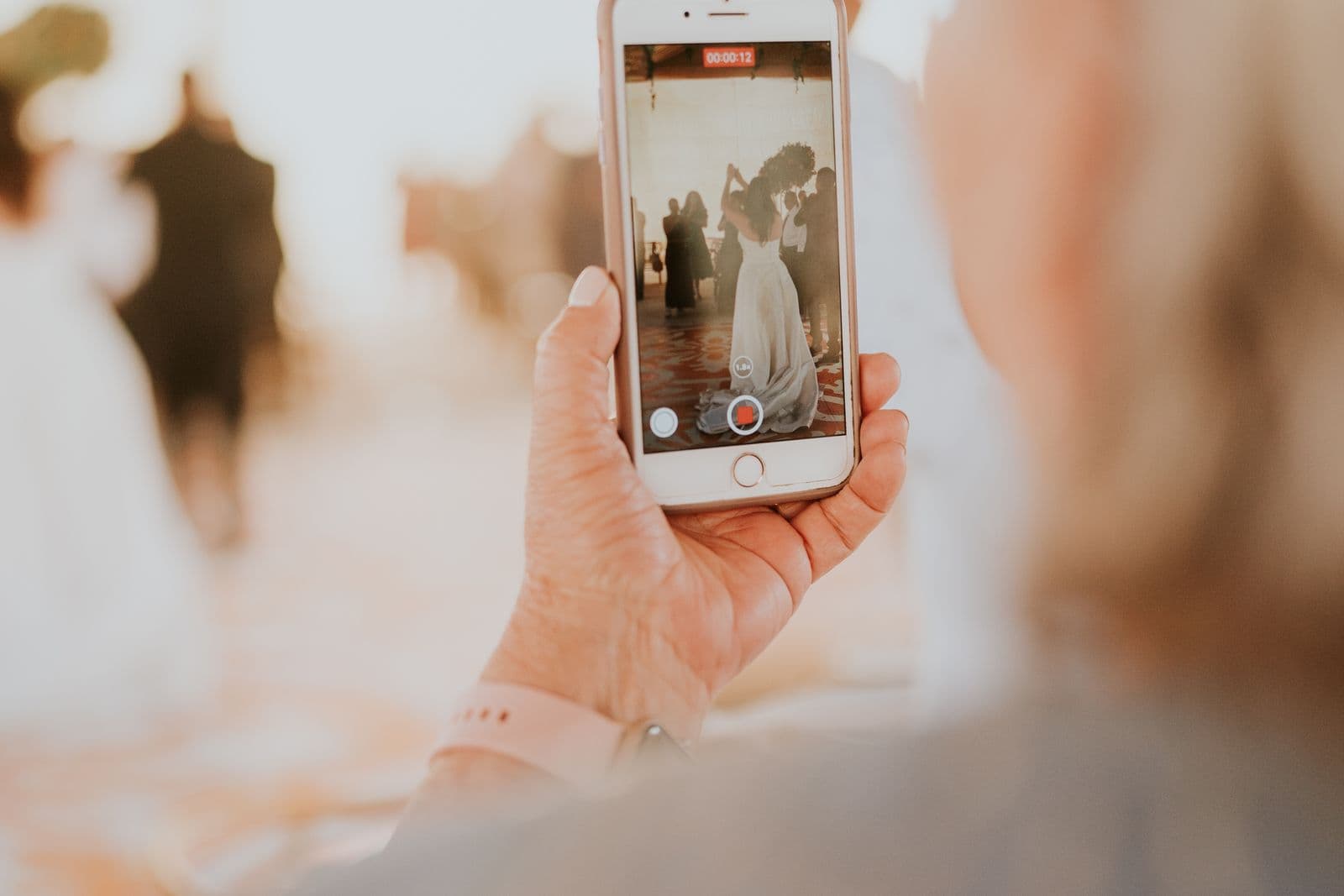 Wedding guest using a phone to photograph the ceremony