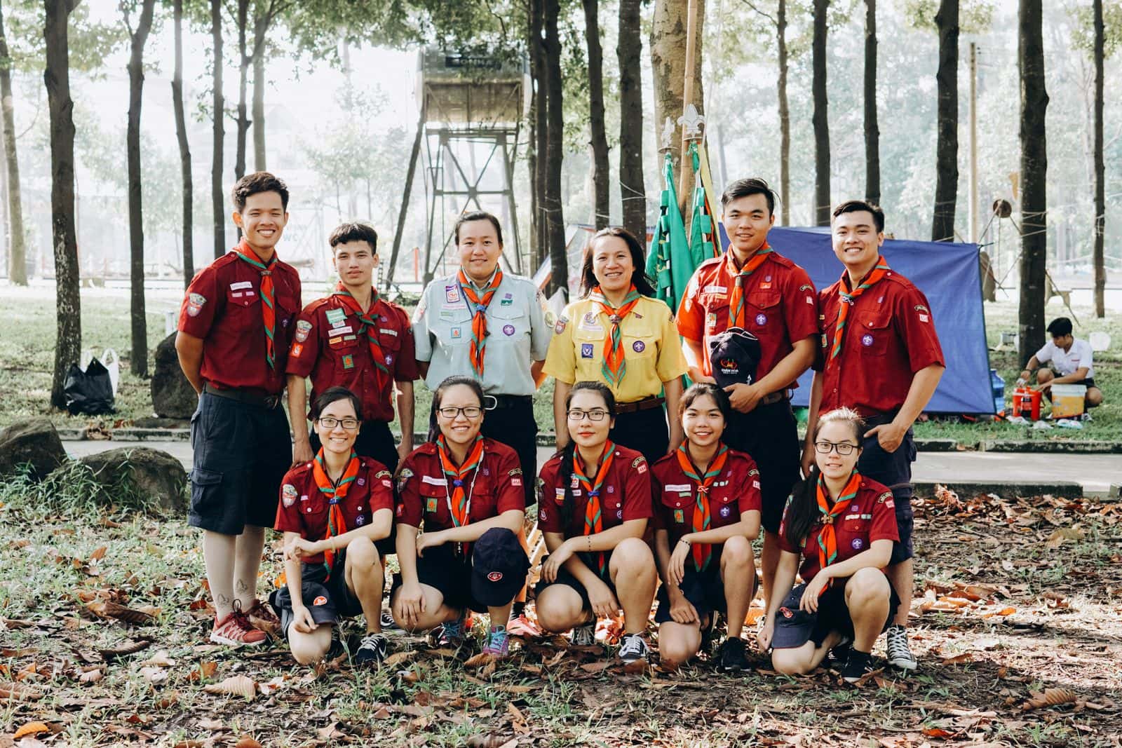 Group of scouts in uniform posing together outdoors at a summer camp