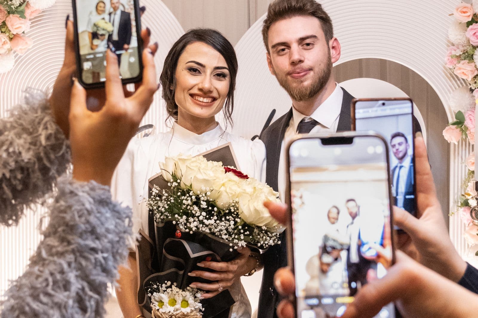Hochzeitsgäste fotografieren das Brautpaar mit ihren Smartphones
