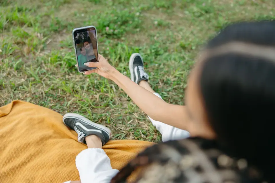 Woman holding up a phone for a clear outdoor selfie