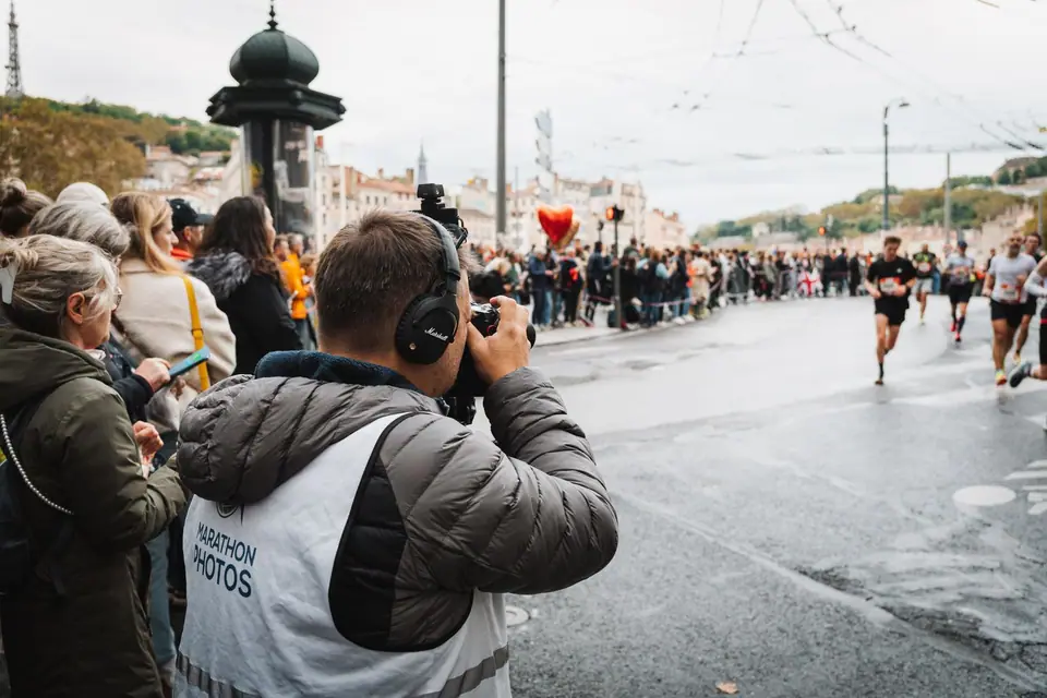 Race photographer capturing runners from the course edge