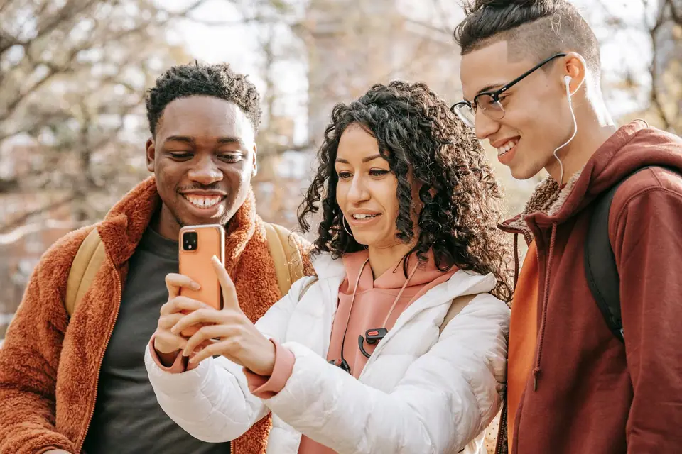 Group of friends in a park taking a selfie on a smartphone