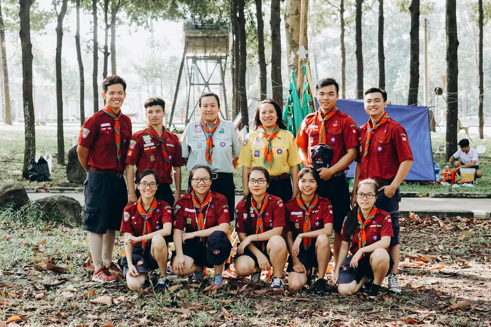 Group of scouts in uniform posing together outdoors at a summer camp