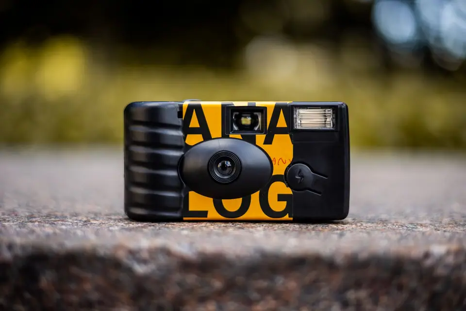 Disposable film camera resting on a stone ledge