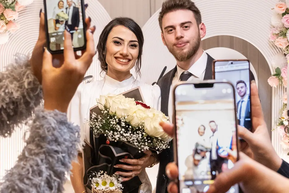 Wedding guests photographing the newlyweds with their smartphones